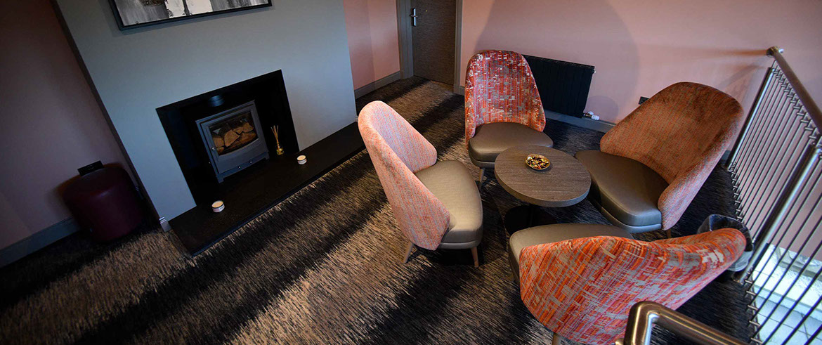 Relax in Taransay House Luxury Accommodation in Portree public seating area with woodburning stove