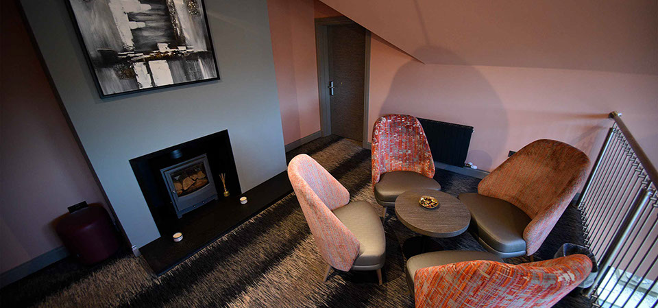 Relax in Taransay House Luxury Accommodation in Portree public seating area with woodburning stove