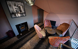 Relax in Taransay House Luxury Accommodation in Portree public seating area with woodburning stove